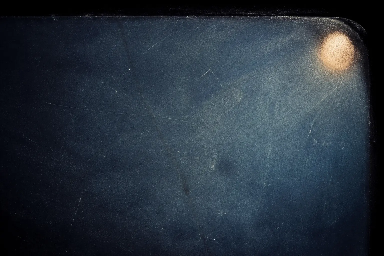 Original artwork of a single overexposed frame edge with a small circular burn mark in the upper corner of dark blue.